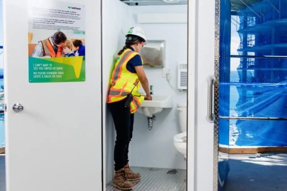 Woman worker on active construction site washing their hands in an H³ Wellness Pod
