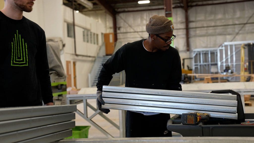 Worker moving steel frame construction materials