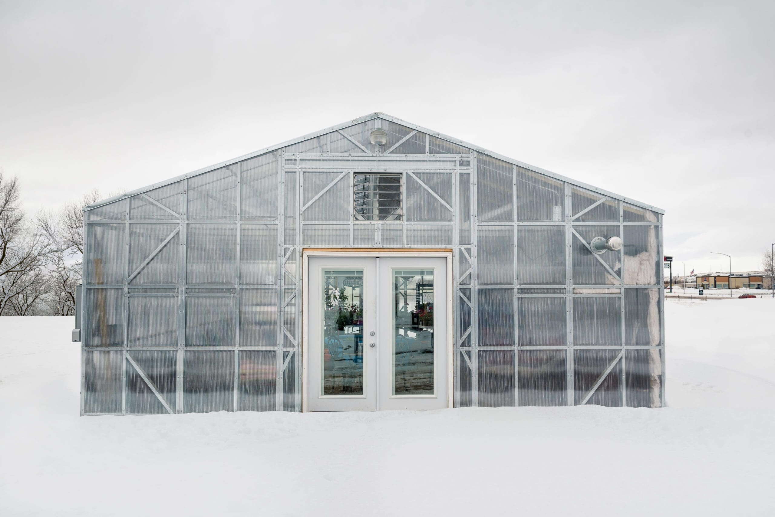 Completed Greenhouse in field with white doors in winter completed by B & T Manufacturing.