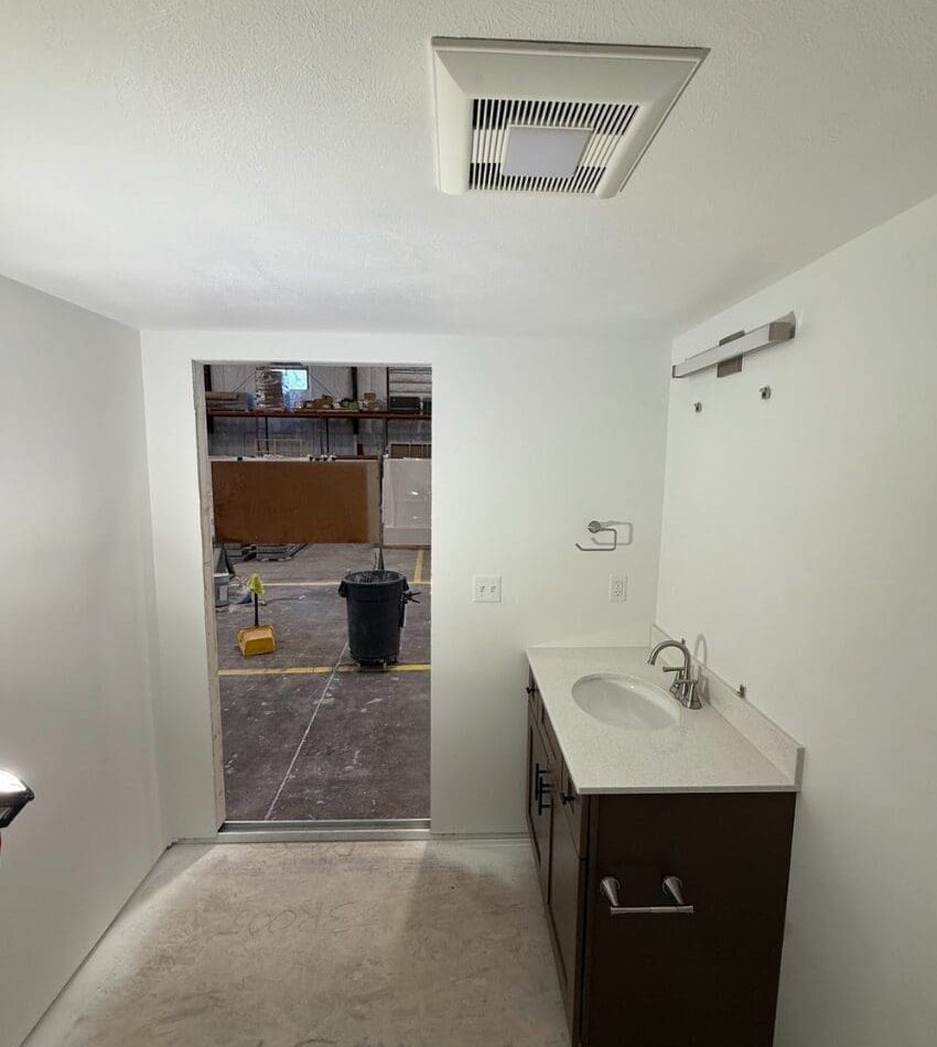 Floorless bathroom interior entrance with bathroom vanity, sink, lighting, and fan