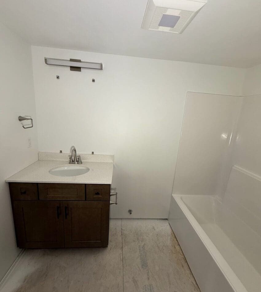 Floorless bathroom interior with bath and shower, sink vanity and lighting