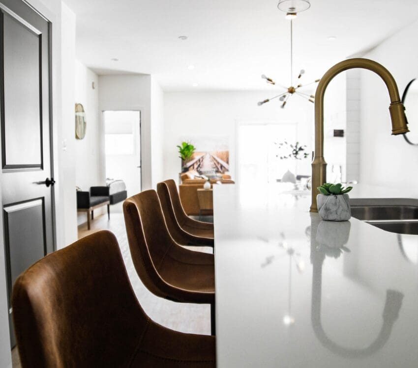 Workforce housing kitchen with granite island and leather bar stools