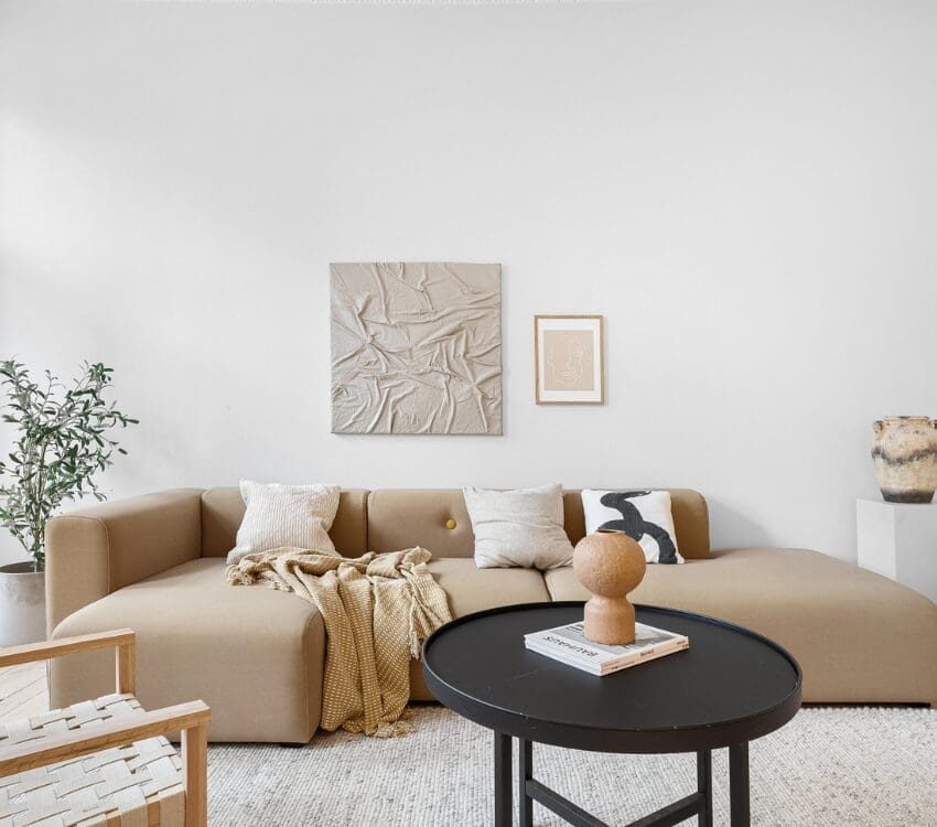 Workforce housing interior with modern decorations, couch, chair, art on walls, and coffee tables